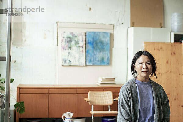 Lächelnder Maler  der in der Kunstwerkstatt sitzt