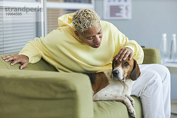 Frau streichelt Hund in Tierklinik