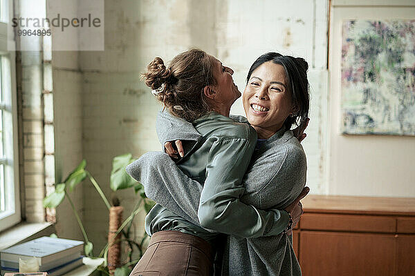 Happy women hugging each other at art studio
