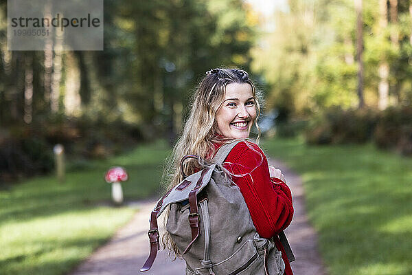 Glückliche Frau mit Rucksack im Cannock Chase Forest