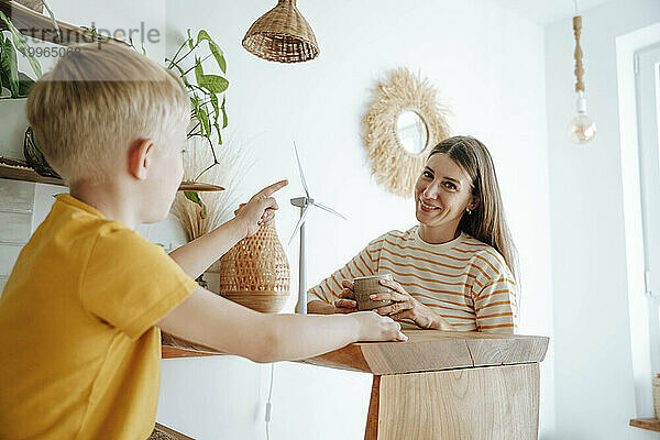 Mutter und Sohn zu Hause mit Windturbinenmodell