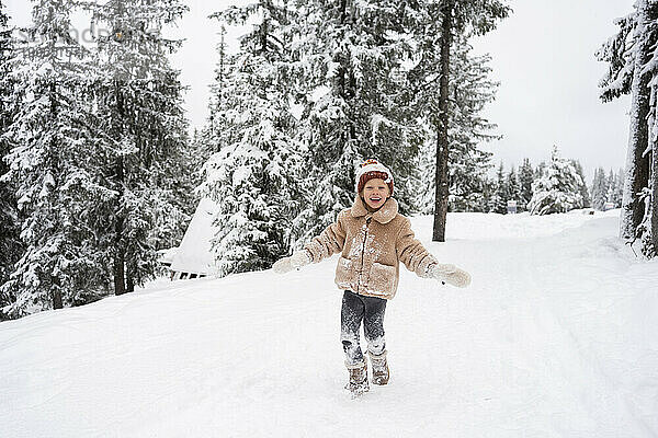 Lächelndes Mädchen genießt den Winterwald
