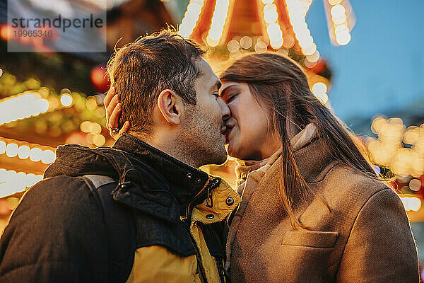 Loving couple kissing at Christmas market