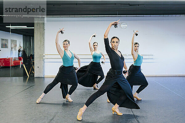 Selbstbewusster Lehrer tanzt Flamenco mit Schülern im Studio