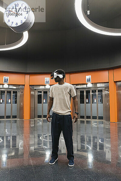 Young man using Virtual Reality Simulator at Metro Station
