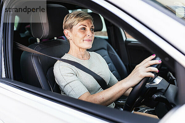 Reife Frau trägt Sicherheitsgurt und fährt Auto