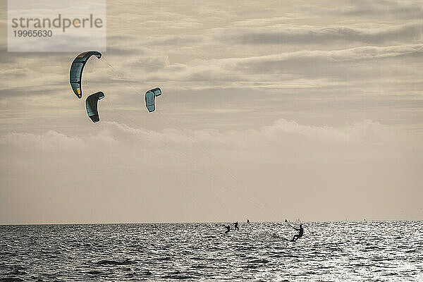 Netherlands  Friesland  Terschelling  Three kiteboarders at dusk