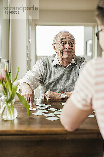 Großvater und Enkel spielen zu Hause Karten