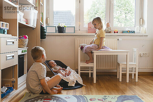 Baby Junge mit Geschwistern im Schlafzimmer zu Hause