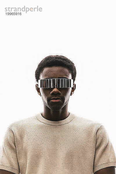 Cool young man wearing cyber glasses against white background