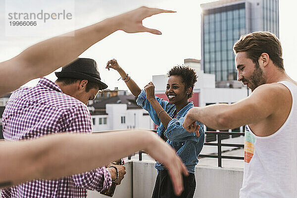 Fröhliche Freunde tanzen auf dem Dach