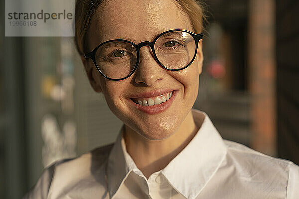 Lächelnde schöne Geschäftsfrau mit Brille