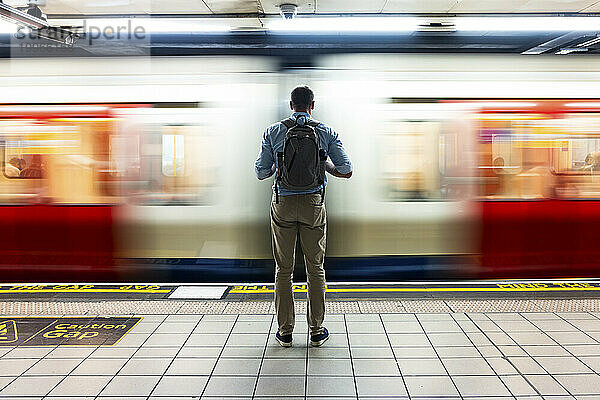 Geschäftsmann wartet auf Zug auf U-Bahn-Plattform