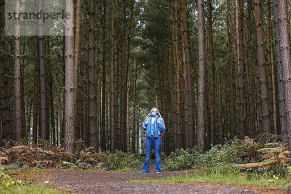 Frau steht in der Nähe von Bäumen im Wald von Cannock Chase