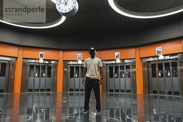 Junger Mann nutzt Virtual-Reality-Simulator an der U-Bahn-Station