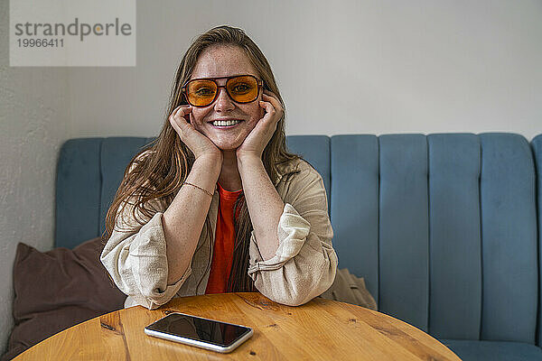 Glückliche Frau mit Sonnenbrille und sitzt im Café