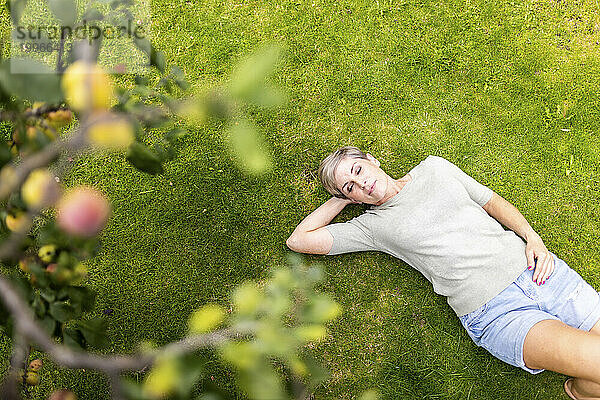 Woman lying down on grass in garden
