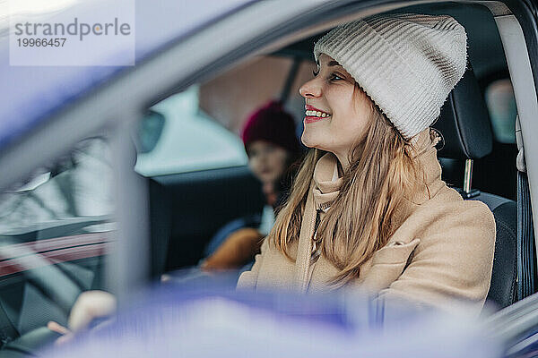 Lächelnde Frau  die im Winter Auto fährt