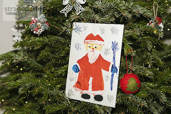 Weihnachtsmann-Gemälde hängt am Weihnachtsbaum