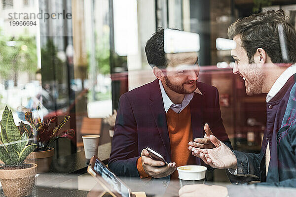 Glückliche Geschäftsleute diskutieren im Café