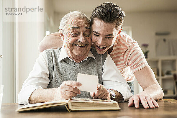 Happy grandfather and grandson looking at photographs together