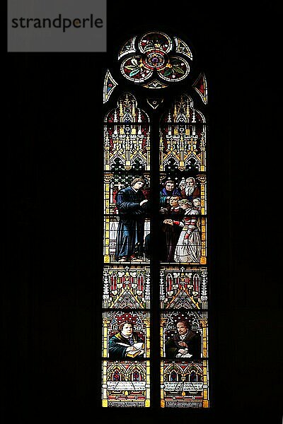 Buntes Kirchenfenster mit Reformatoren Martin Luther mit Schreibfeder und Bibel und Philipp Melanchthon mit Schriftrolle  Reformator  Glasmalerei  Kunsthandwerk  Kirchengeschichte  Berühmtheit  schwarz  Silhouette  Katharinenkirche  Oppenheim  Rheinhessen  Rheinland-Pfalz  Deutschland  Europa