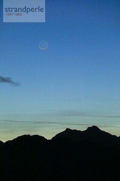 Mondsichel über Berg Silhouette  Wallis  Schweizer Alpen