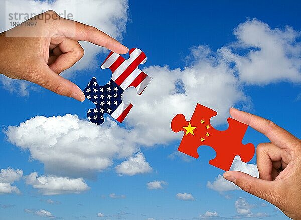 Puzzleteile  Zwei Hände halten jeweils ein Puzzleteil  USA  China  Studio  Asien