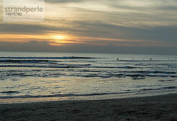 Sonnenuntergang am Strand von Bali mit Silhouette von Surfern im Wasser  Südkorea  Asien