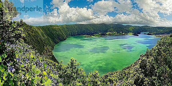 Atemberaubender Panoramablick auf den Kratersee Lagoa Azul umgeben von steilen Felswänden unter heiteren Himmel  Krater Rundwanderweg  Caldeira das Sete Cidades  Sete Cidades  Insel Sao Miguel  Azoren  Portugal  Europa