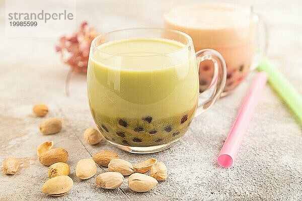 Bubble Tea mit Pistazie und Karamell im Glas auf braunem Beton Hintergrund. Gesundes Getränk Konzept. Seitenansicht  Nahaufnahme  selektiver Fokus