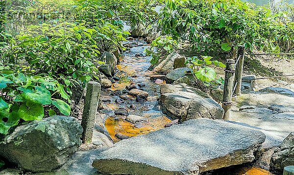 Kleiner Bach  der unter einer Betonbrücke im japanischen Gartenpark in Hiroshima  Japan  fließt  Asien