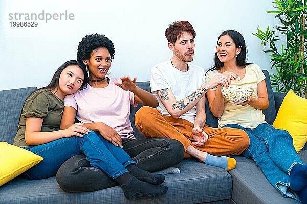 Verschiedene Freunde  die zusammen auf dem Sofa in einer Wohnung sitzen und einen Film ansehen