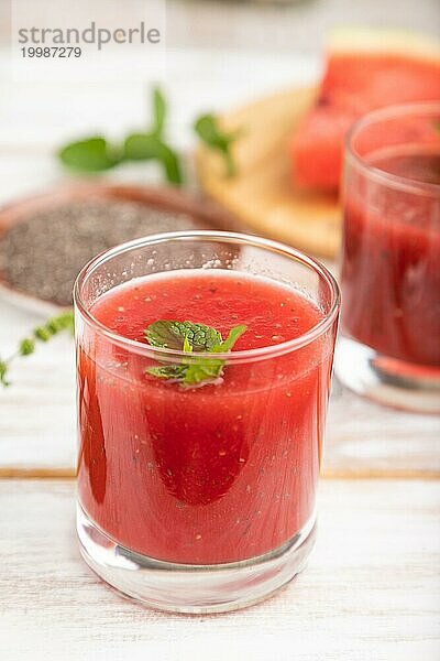 Wassermelonensaft mit Chiasamen und Minze in einem Glas auf einem weißen Holzhintergrund mit Leinenstoff. Gesundes Getränk Konzept. Seitenansicht  Nahaufnahme  selektiver Fokus