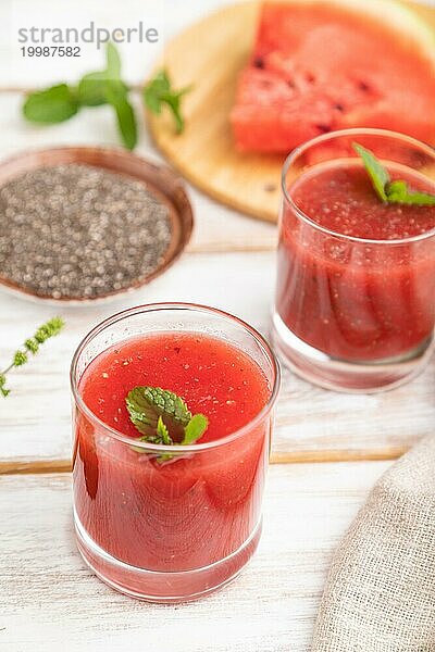 Wassermelonensaft mit Chiasamen und Minze in einem Glas auf einem weißen Holzhintergrund mit Leinenstoff. Gesundes Getränk Konzept. Seitenansicht  Nahaufnahme  selektiver Fokus