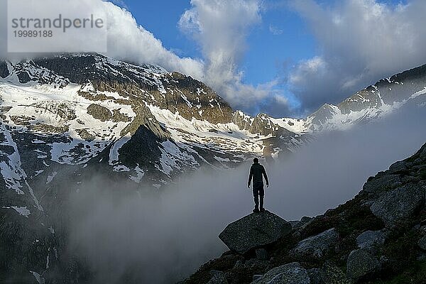 Silhouette eines Bergsteigers vor wolkenverhangener stimmungsvoller Berglandschaft  felsige verschneite Berge  Furtschaglhaus  Berliner Höhenweg  Zillertaler Alpen  Tirol  Österreich  Europa