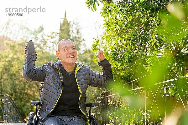 Ein behinderter Mann im Rollstuhl genießt das Leben und die Natur in einem Park