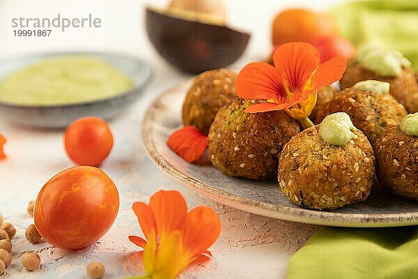 Falafel mit Guacamole auf weißem Betonhintergrund und grünem Leinentuch. Seitenansicht  Nahaufnahme  selektiver Fokus