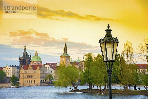 Unscharfe Ansicht der Insel Strelecky in der Moldau und der Altstadt von Prag  Tschechische Republik  bei Sonnenuntergang. Selektiver Fokus auf die Straßenlaterne  Europa