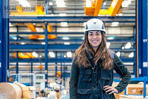 Porträt einer lächelnden Arbeiterin mit Schutzkleidung in einem Logistikzentrum