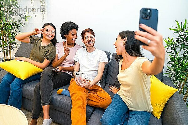 Multiethnische Freunde  die Spaß daran haben  ein Selfie zu machen  während sie zusammen auf einer Couch zu Hause sitzen