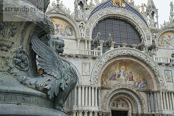 Altes Straßenornament mit geflügelten Löwen und der Basilika San Marco im Hintergrund  auf dem Markusplatz  einer berühmten Touristenattraktion in Venedig  Italien. Selektiver Fokus