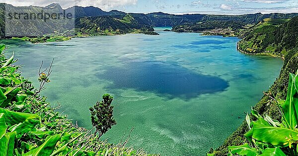 Beruhigender Blick auf den blauen See Lagoa Azul mit der grünen Hügellandschaft unter einem heiteren Himmel  Lagoa Azul  Rundwanderweg  Caldeira das Sete Cidades  Sete Cidades  Insel Sao Miguel  Azoren  Portugal  Europa