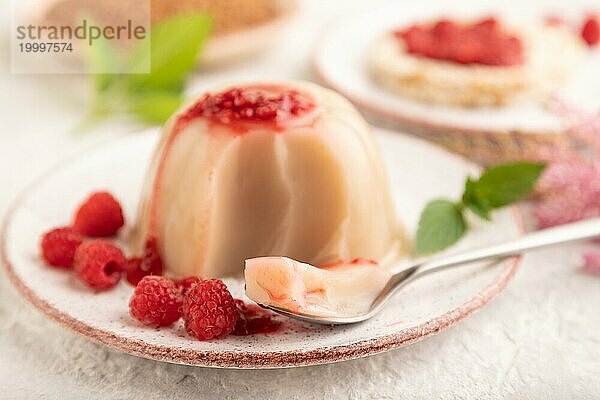 Buchweizenmilchgelee mit Himbeermarmelade auf grauem Betonhintergrund. Seitenansicht  selektiver Fokus