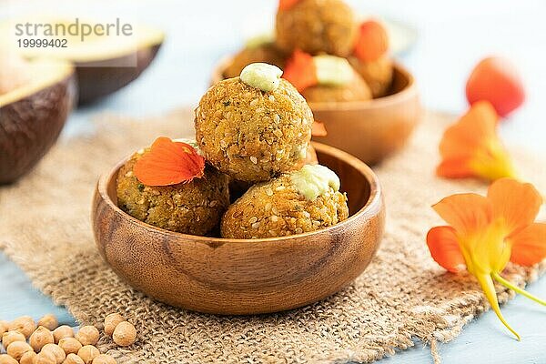 Falafel mit Guacamole auf blauem Holzhintergrund und Leinentextil. Seitenansicht  Nahaufnahme  selektiver Fokus