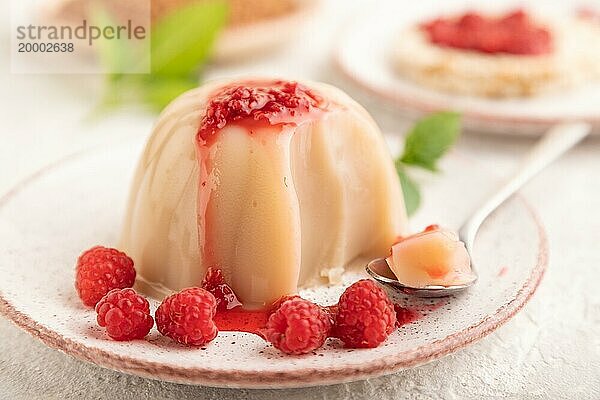 Buchweizenmilchgelee mit Himbeermarmelade auf grauem Betonhintergrund. Seitenansicht  selektiver Fokus