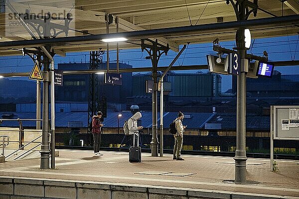 Menschen auf dem Bahnsteig frühmorgens vor dem Edelstahlwerk  Hauptbahnhof  Witten  Nordrhein-Westfalen  Deutschland  Europa