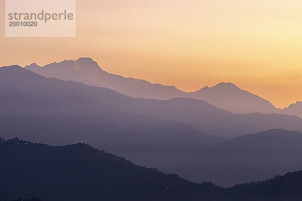 Silhouette der Himalaya Gipfel  einschließlich Himalchuli und Baudha Himal  im Gegenlicht des orangefarbenen Himmels  gesehen kurz vor Sonnenaufgang an einem Wintermorgen im Januar von Sarangkot  dem beliebten Aussichtspunkt oberhalb von Pokhara. Bezirk Kaski  Provinz Gandaki  Nepal  Asien