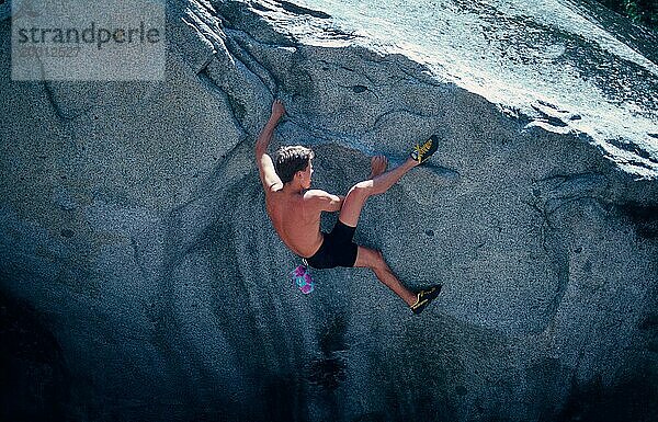 Junger Mann mit Kletterschuhen  Chalkbag  Bouldern im Yosemite Valley  Kalifornien  USA  Freeclimbing  Nordamerika