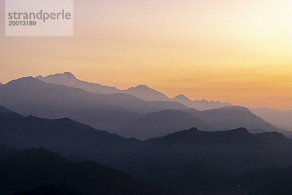 Silhouette der Himalaya Gipfel  einschließlich Himalchuli und Baudha Himal  im Gegenlicht des orangefarbenen Himmels  gesehen kurz vor Sonnenaufgang an einem Wintermorgen im Januar von Sarangkot  dem beliebten Aussichtspunkt oberhalb von Pokhara. Bezirk Kaski  Provinz Gandaki  Nepal  Asien